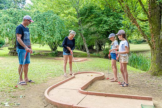 Famille jouant au mini-golf sur le parcours du camping CAPFUN Moulinal à BIRON (24).