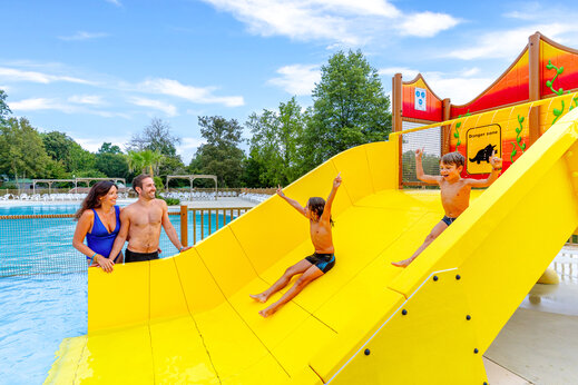 Toboggan aquatique jaune et piscine avec famille au camping CAPFUN Moulinal à BIRON (24).