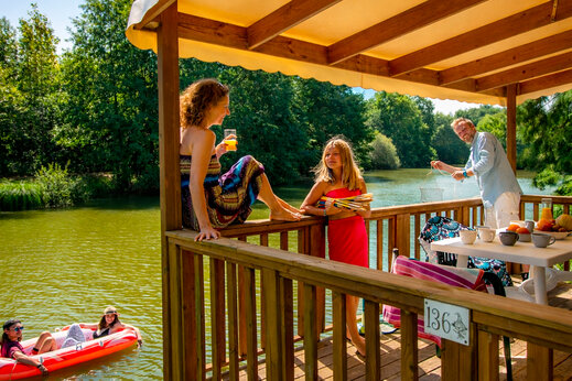 Famille profitant de la terrasse d'un Mobil-home au bord du lac, CAPFUN Moulinal à BIRON (24).