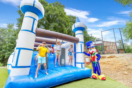 Riesige Hüpfburg mit Kindern und Maskottchen auf dem Campingplatz CAPFUN Moulinal in BIRON (24).