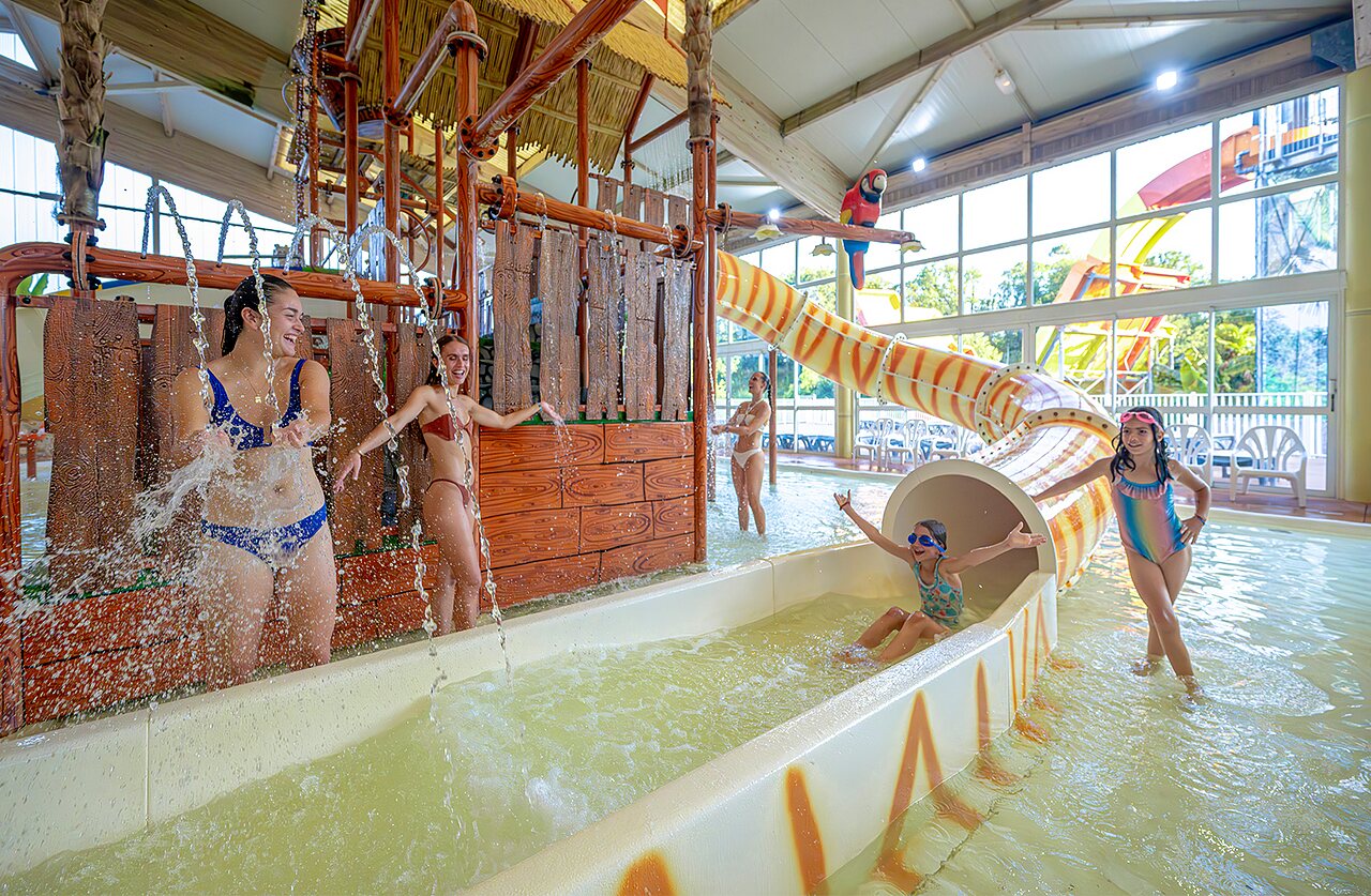 Overdekt zwembad, glijbaan en waterspelen op camping VAGUES OCEANES Moulin de Cadillac in Noyal-Muzillac (56).