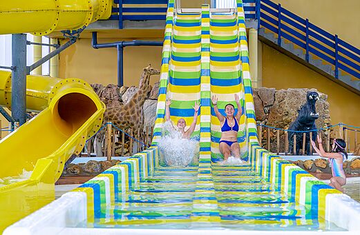 Bunte Wasserrutschen und Badegäste am Campingplatz VAGUES OCEANES Moulin de Cadillac (56).