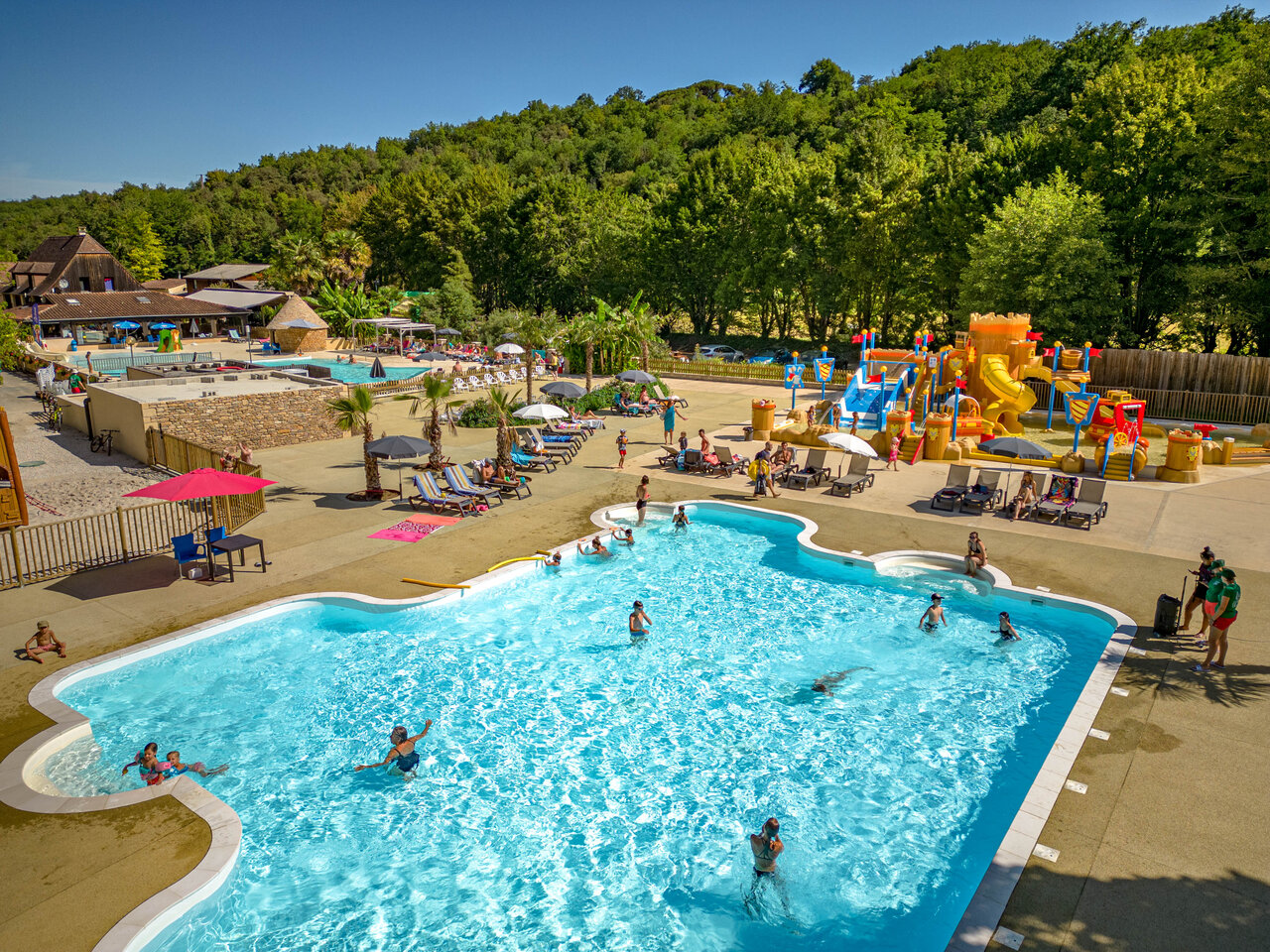 Outdoor swimming pool, slides and water playground at CLICOCHIC Moulin du Roch campsite in Saint Andre D'Allas.