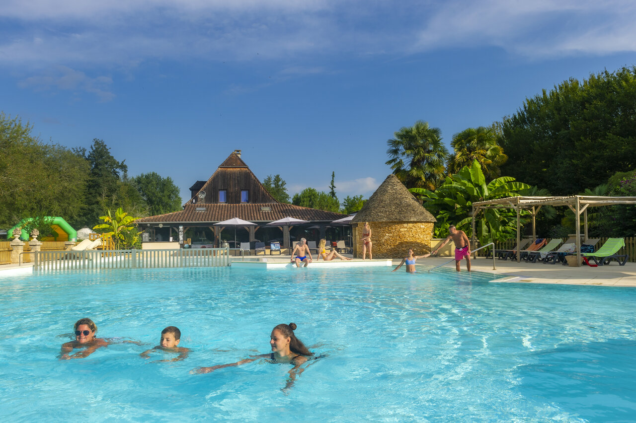 Family outdoor swimming pool, main building and games, at the campsite CLICOCHIC Moulin du Roch.