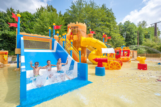 Wasserspielplatz mit Rutschen und Kindern auf dem Campingplatz CLICOCHIC Moulin du Roch in Saint Andre D'Allas.
