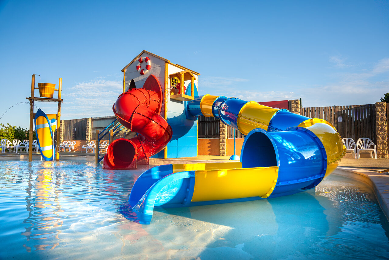 Colorful water slides and water games in the swimming pool at CAPFUN La Nautique campsite in Narbonne (11).