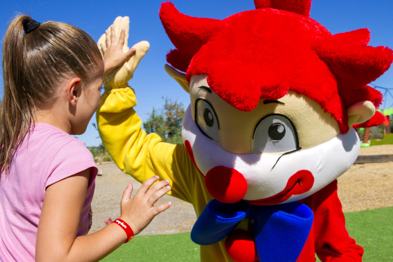 Child high-fiving mascot at CAPFUN La Nautique campsite in Narbonne (11).