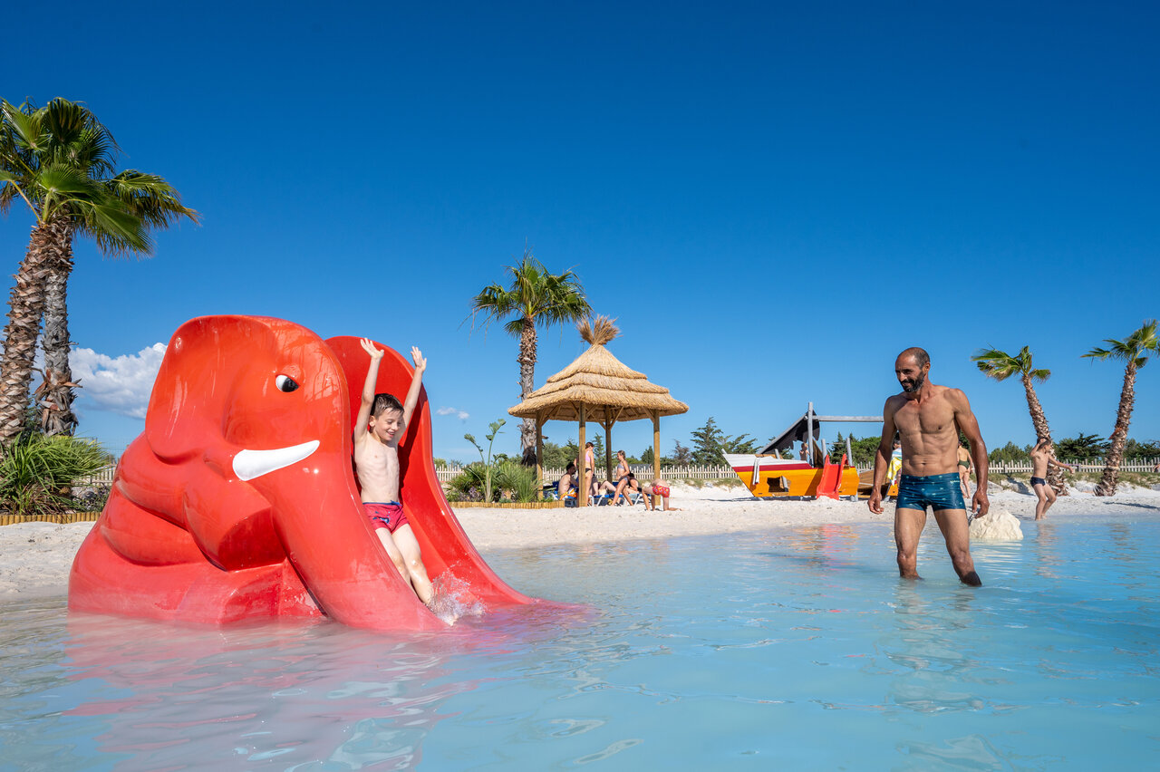 Child on elephant slide, fun pool at CAPFUN La Nautique campsite in Narbonne (11).