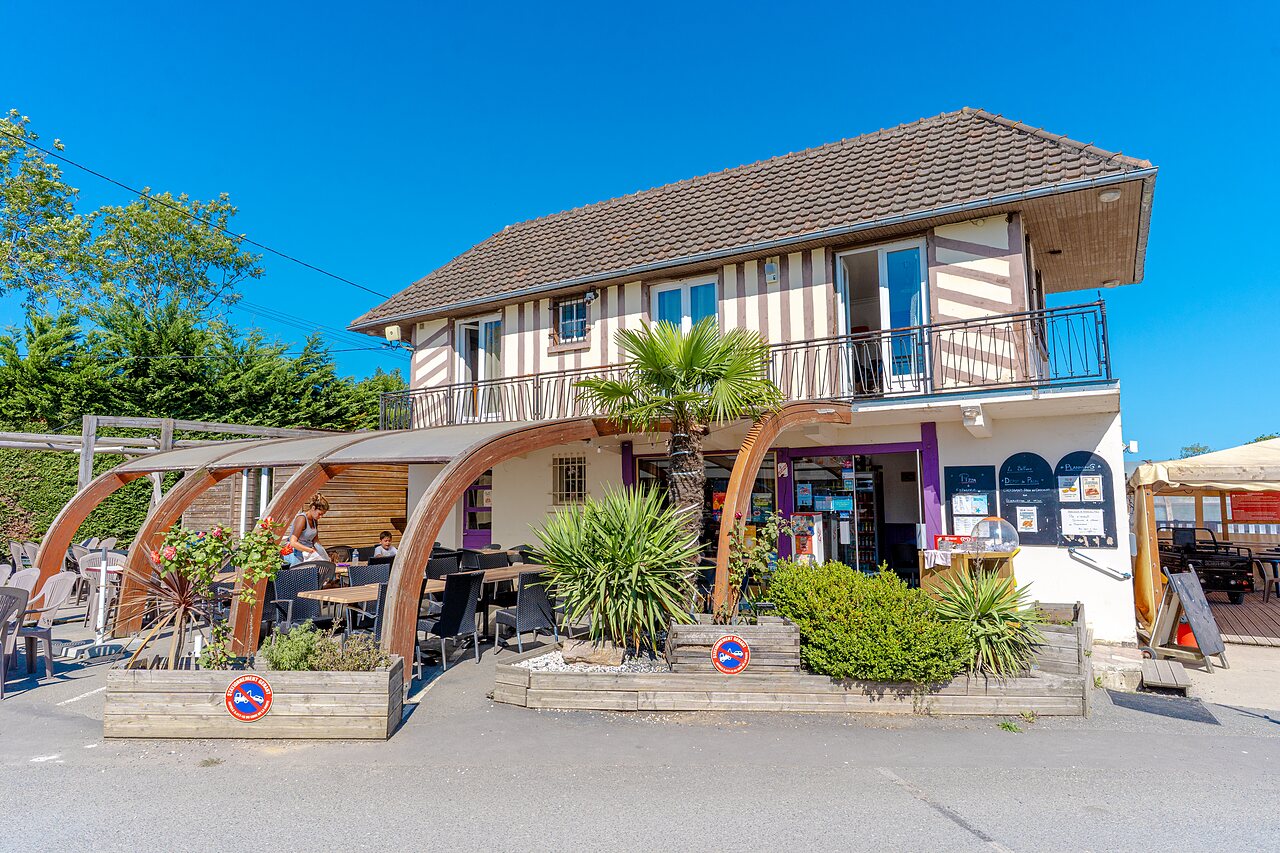 Restaurant and covered outdoor terrace with tables at VAGUES OCEANES Odyss�e campsite in Villers sur mer (14).