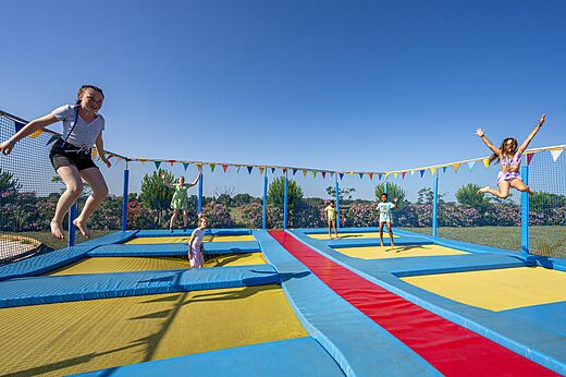 Speeltuin met trampolines en springende kinderen op camping CAPFUN Ondines in Vias Plage (34).