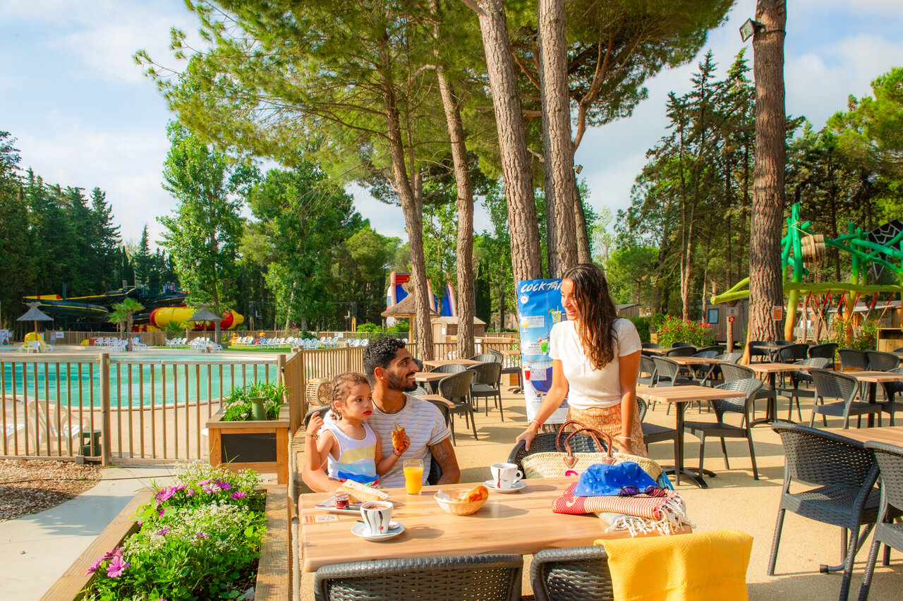 Familie fr�hst�ckt auf Terrasse am Pool auf dem Campingplatz CAPFUN Or in La Grande Motte (34).