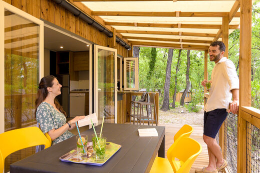 Paar auf der Terrasse eines modernen Mobilheims auf dem Campingplatz CLICOCHIC Or�e d'Azur in OPIO (06).