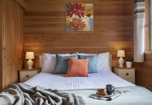 Komfortables Mobilheim-Schlafzimmer mit Doppelbett auf dem Campingplatz CAPFUN UK Otter Falls.
