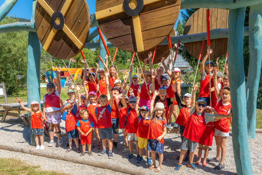 Lachende Kinder spielen auf Holzspielplatz auf Camping CAPFUN Oursière in Villard de Lans (38).