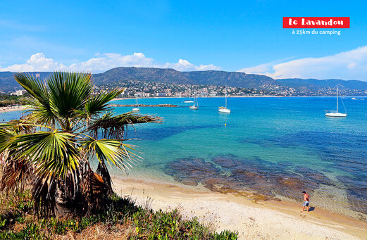 Feiner Sandstrand, türkisfarbenes Meer und Segelboote in Le Lavandou, Var.