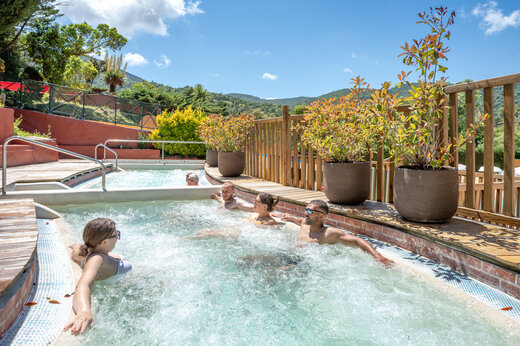 Sprudelnder Außen-Whirlpool mit Gästen auf Camping CAPFUN Pachacaid in La Mole (83).