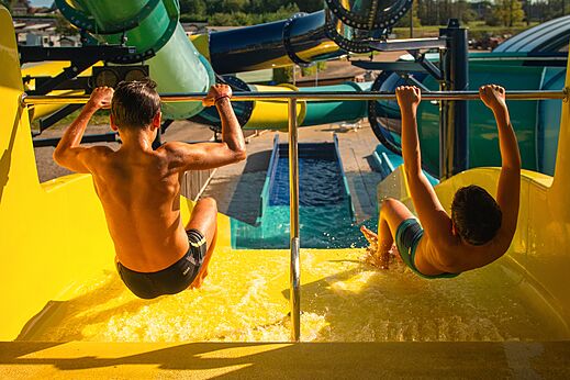 Kinder rutschen eine gro�e gelbe Wasserrutsche hinunter auf Camping CAPFUN Pachy in FOSSES LA VILLE.