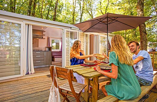 Modernes Mobilheim mit Terrasse und Familienessen auf dem Campingplatz VAGUES OCEANES.
