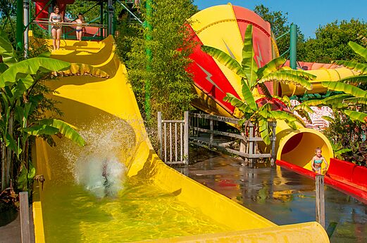 Riesige gelbe und rote Wasserrutschen mit Kindern auf dem Campingplatz CAPFUN Paillotte in AZUR (40).