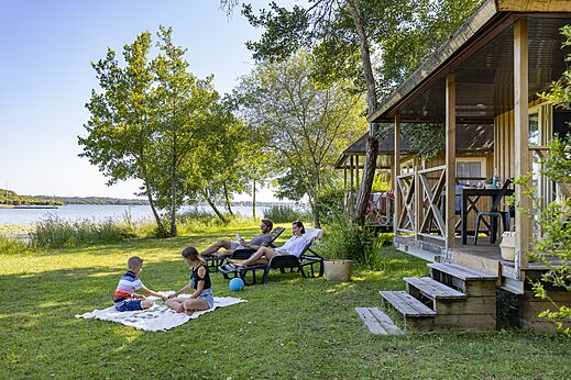 Familie vor Mobilheim und See, Campingplatz CAPFUN Paillotte in AZUR (40).