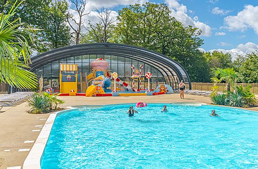 Buitenzwembad en overdekte waterspeeltuin op camping CAPFUN Palais de Gaufrette (57).