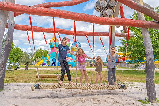 Kinderen op touwschommel van de speeltuin op camping CAPFUN Palais de Gaufrette in R�mering les Puttelange (57).