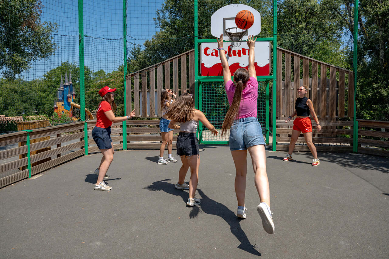 Young people playing basketball on multisport court at CAPFUN Palombi�re campsite in Sarlat.