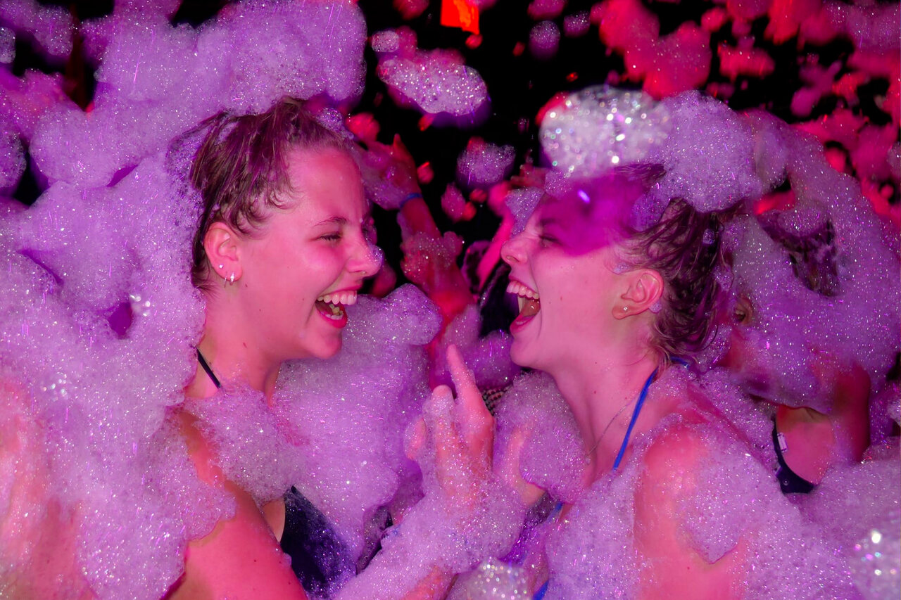 Young women laughing at foam party animation, CAPFUN Palombi�re campsite Sarlat (24).