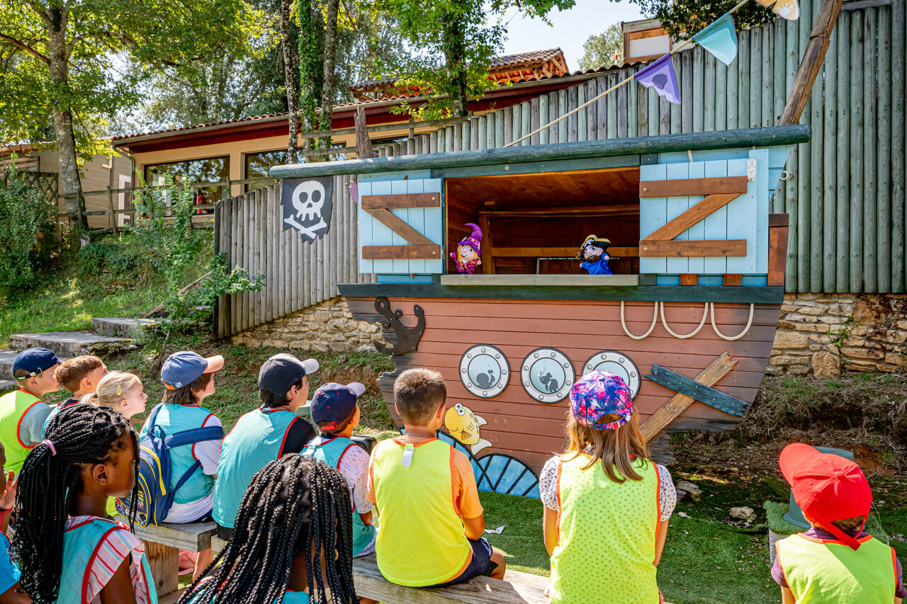 Children watching puppet show on pirate ship stage at CAPFUN Palombi�re campsite in Sarlat (24).