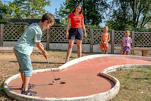 Kind spielt Minigolf auf dem Platz im Camping CAPFUN Palombière in SAINT-NATHALENE (24).