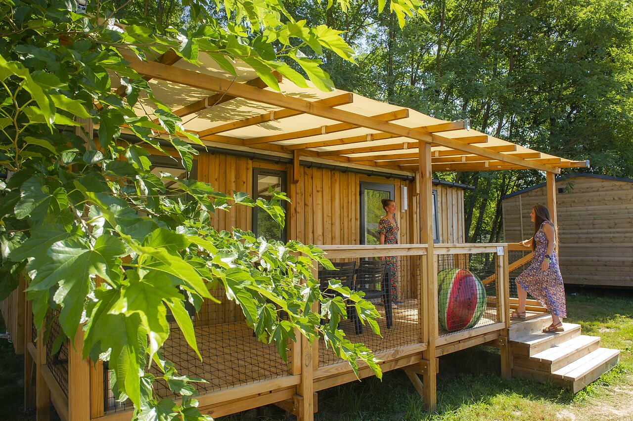 Wooden mobile home with covered terrace at CAPFUN Paradis de Bazas (33).