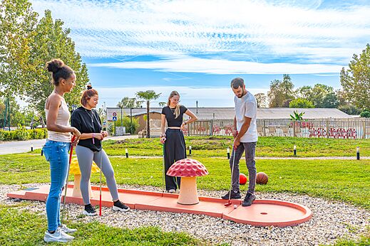 Freunde spielen Minigolf auf dem Campingplatz CAPFUN Parc de Paris in Villevaudé (77).