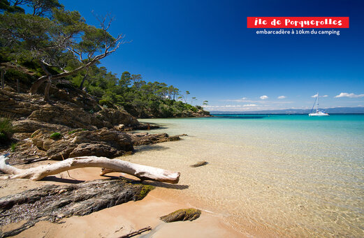 Feiner Sandstrand, türkisfarbenes Wasser und Segelboot nahe der Insel Porquerolles.