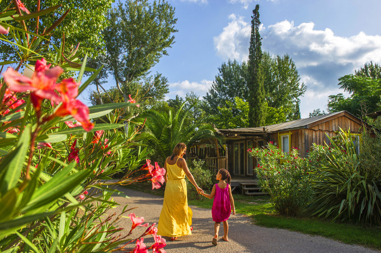 Flowery path and wooden Mobil-home at CAPFUN Paris Roussillon campsite in ARGELES SUR MER (66).