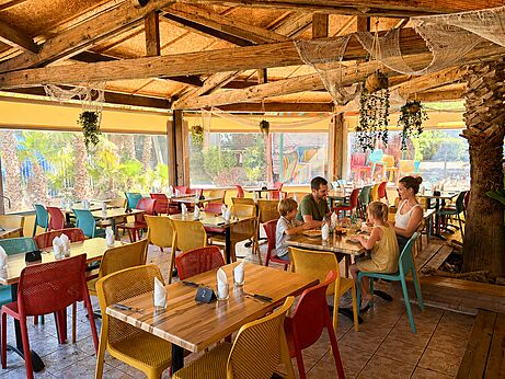 Familienrestaurant mit bunten Tischen auf dem Campingplatz CAPFUN Paris Roussillon in ARGELES SUR MER (66).