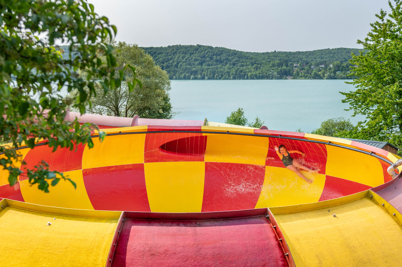 Child sliding down giant water slide, lake view, CAPFUN Pergola campsite Marigny (39).