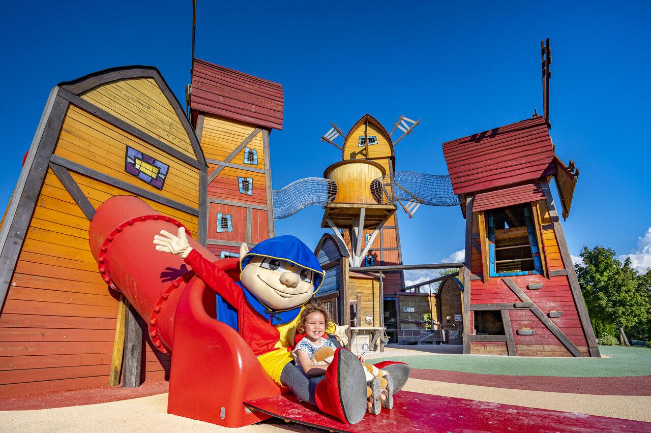 Colorful playground with slide and mascot at CAPFUN Pergola campsite in Marigny (39).