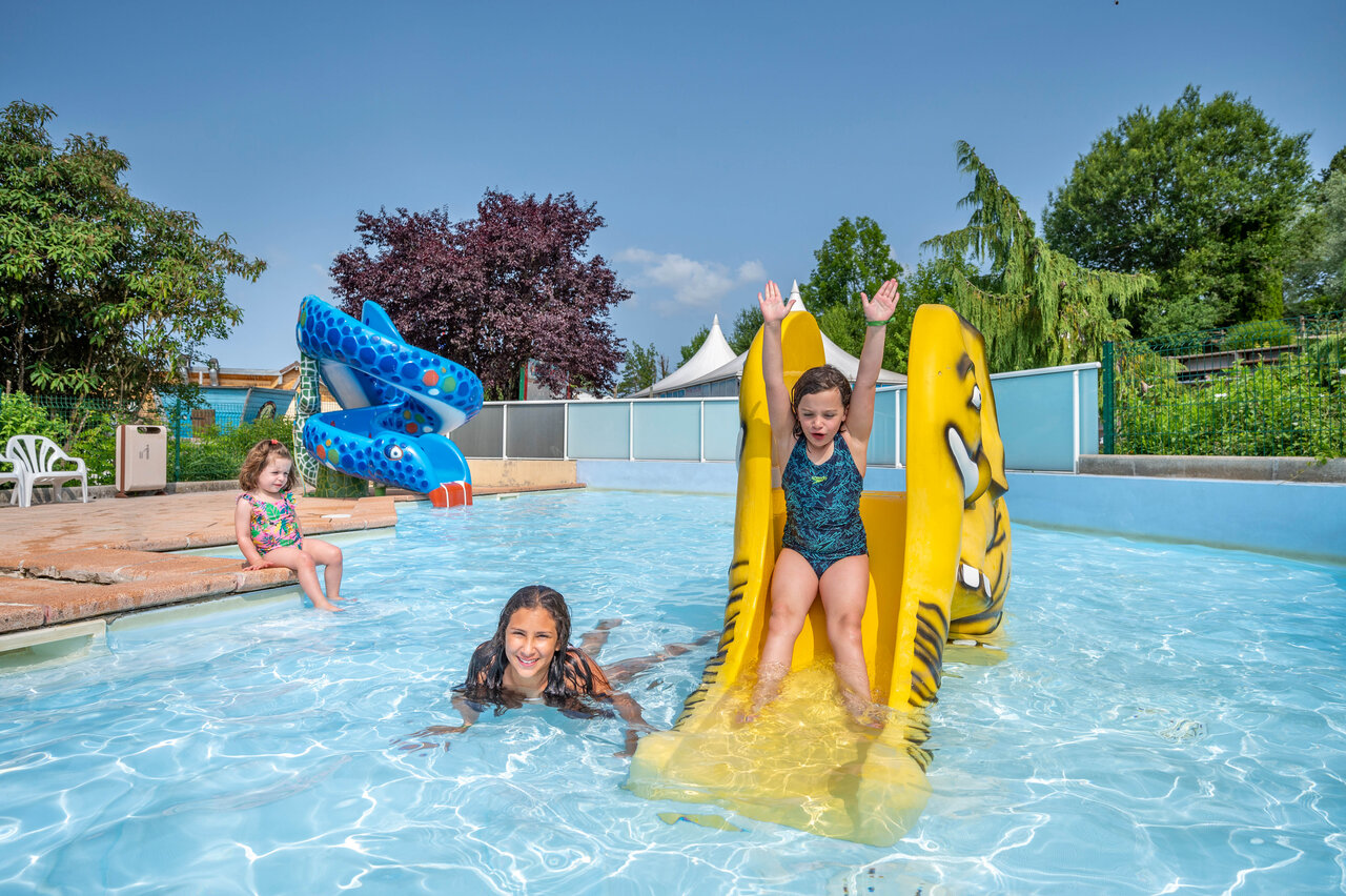 Outdoor swimming pool with water slides and children at CAPFUN Pergola campsite in Marigny (39).