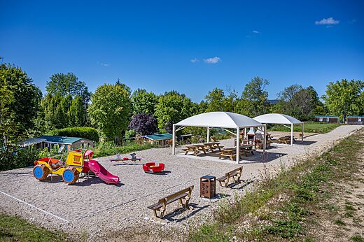 Farbenfroher Spielplatz mit Rutsche und Schaukel auf dem Campingplatz CAPFUN Pergola in Marigny (39).