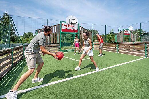 Familie speelt basketbal op het multisportterrein op camping CAPFUN Pergola in Marigny (39).