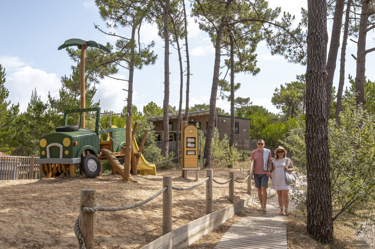 Jeep-f�rmiger Spielplatz und Paar spaziert auf Camping CLICOCHIC Petit Bec in St Hilaire de Riez (85).