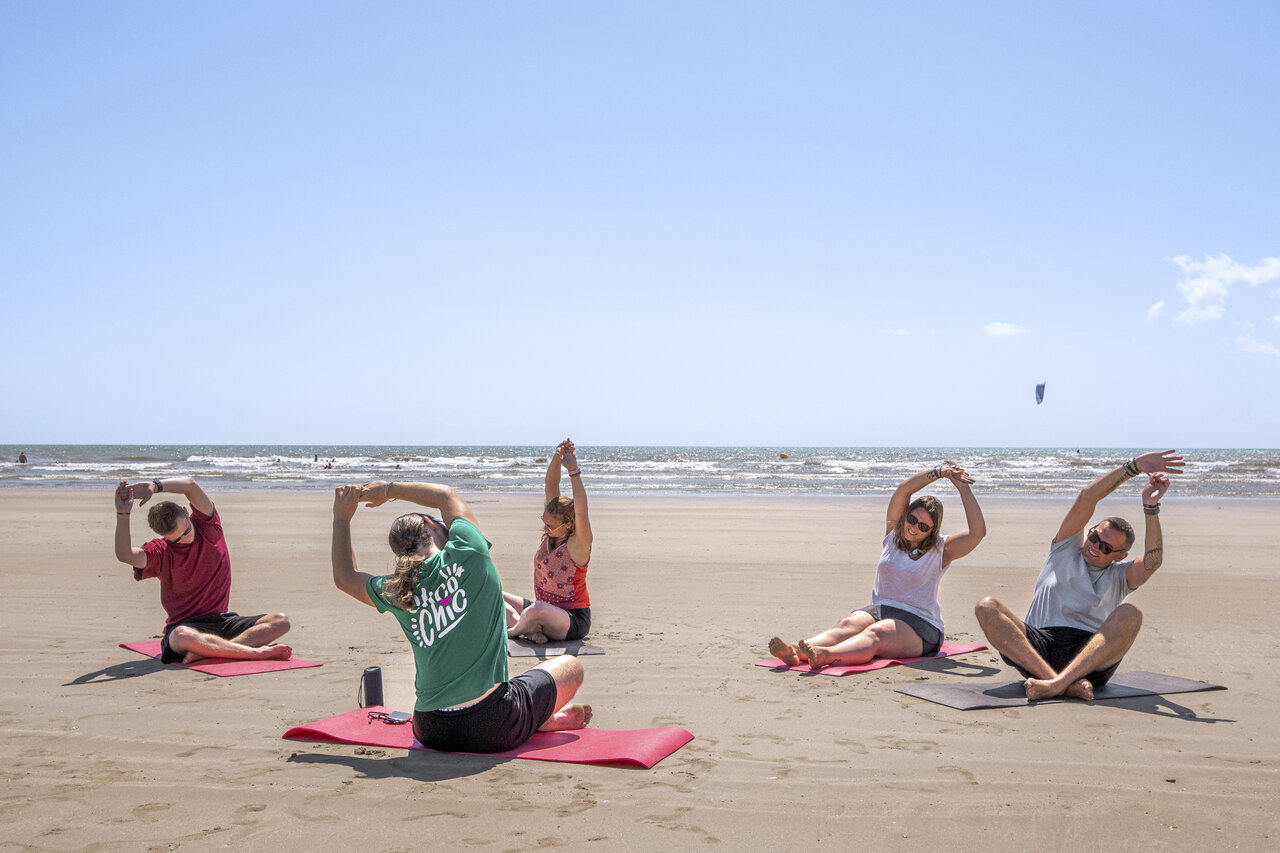 Erwachsene machen Yoga am Strand auf dem Campingplatz CLICOCHIC Petit Bec.