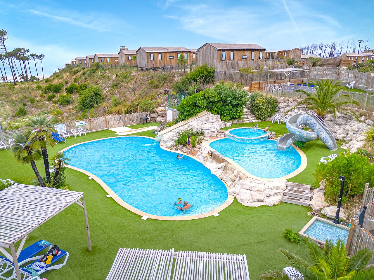 Outdoor pool, waterslides and jacuzzis at CLICOCHIC Petit Nice campsite in PYLA SUR MER.