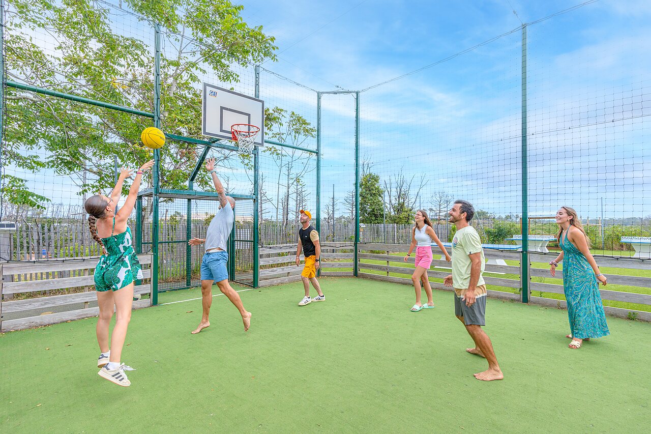 Young people playing basketball on multisport court at CLICOCHIC Petit Nice.