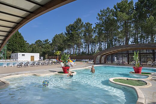 Au�enpool und Kinderbecken mit spielenden Kindern auf dem Campingplatz CAPFUN Pin�da in CAZAUX (33).