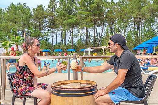 L�chelndes Paar trinkt an der Poolbar auf dem Campingplatz CAPFUN Pin�da in CAZAUX (33).