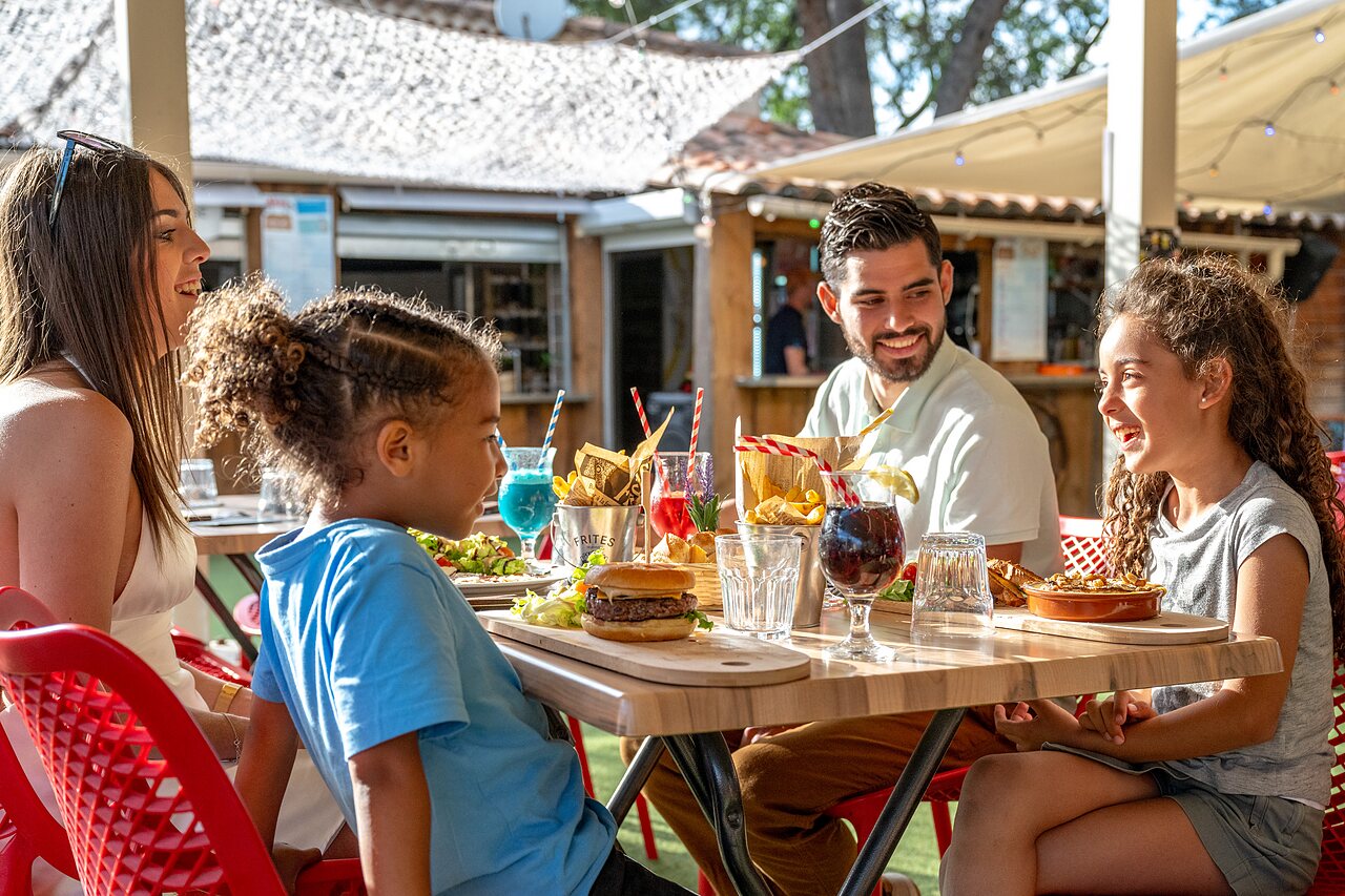 L�chelnde Familie isst im Restaurant des Campingplatzes CAPFUN Pin�des du Luberon, PERTUIS (84).