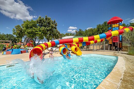 Kleurrijke waterglijbanen en buitenzwembad op camping CAPFUN Pinèdes du Luberon, PERTUIS (84).