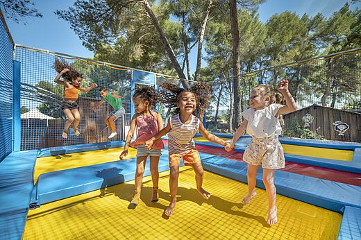 Kinder springen auf den Trampolinen des Campingplatzes CAPFUN Pinèdes du Luberon in PERTUIS (84).