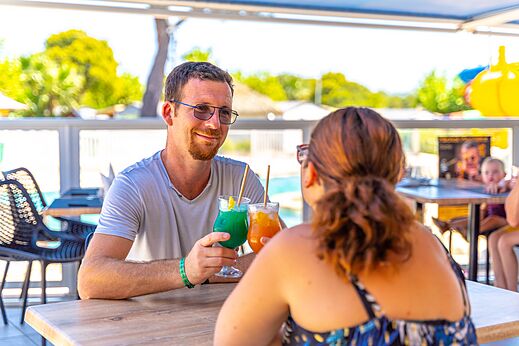Paar genießt Cocktails an der Bar des Camping CAPFUN La Pinède de Grimaud.